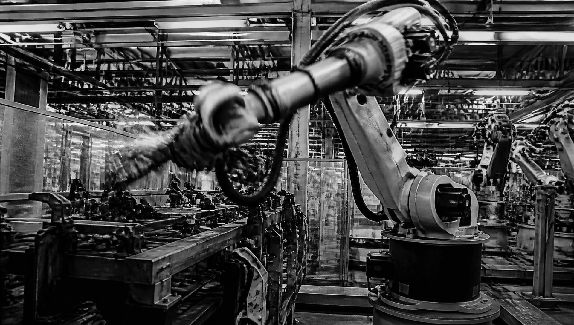 Industrial robot arm working mid-cycle on a factory assembly line